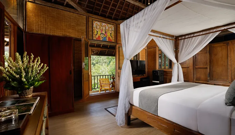 Beautiful master bedroom with a four-poster bed and traditional joglo style architecture at Leona Valley View 1BR