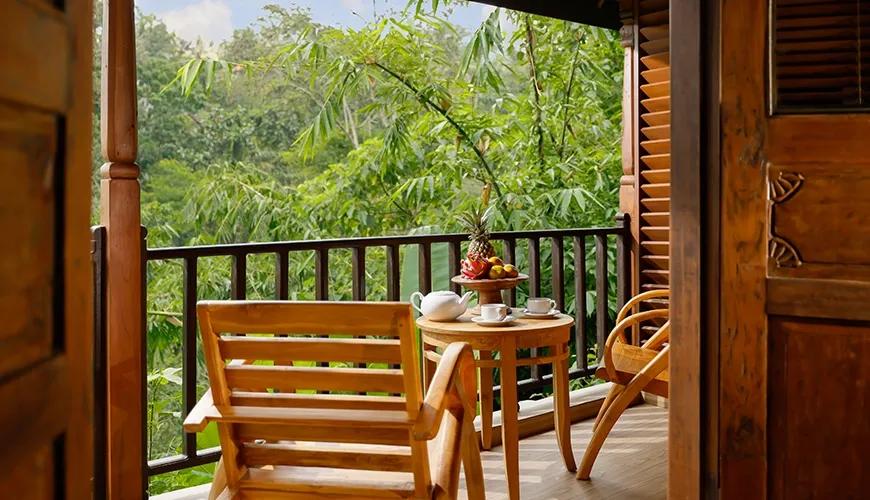 Peaceful villa terrace with a small wooden table overlooks a lush green bamboo jungle view at Leona Valley View 1BR