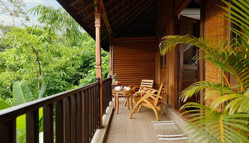 Peaceful wooden villa terrace with chairs and a small table overlooks the jungle view at Leona Valley VIew 1BR