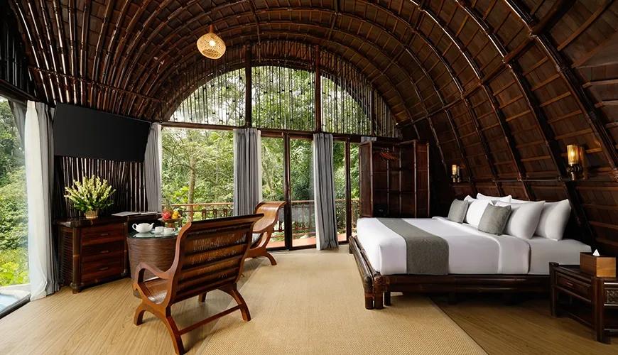 Spacious master bedroom with an arched bamboo ceiling and large windows overlooking the jungle at Leona Valley View 1BR