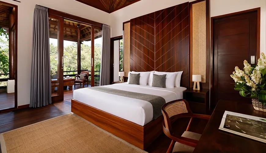 Comfortable master bedroom featuring a large bed, elegant wooden headboard, and a private balcony view at Leona Valley View 2BR