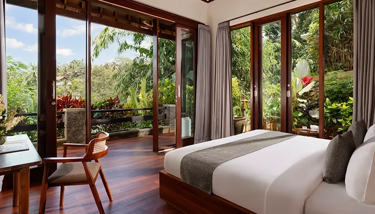 Spacious bedroom with large glass doors that open to a lush green tropical view at Leona Valley View 2BR