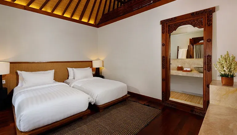 Bali villa twin bedroom features wooden accents at Nelayan Villa