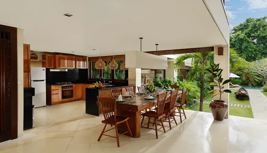 Open kitchen and dining space facing lush garden at Nelayan Villa