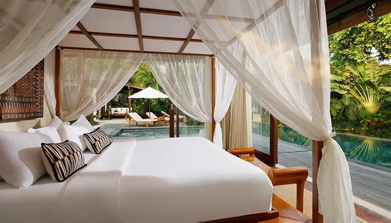 Serene bedroom in Bali villa with pool access at Nelayan Villa