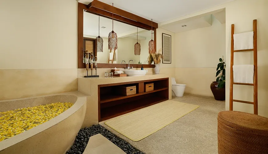Serene villa bathroom with a unique freestanding stone tub and a stylish wooden vanity for a spa-like retreat at Nelayan Villa