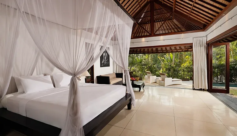 Bedroom features a draped bed and stunning views of lush greenery at Omecure