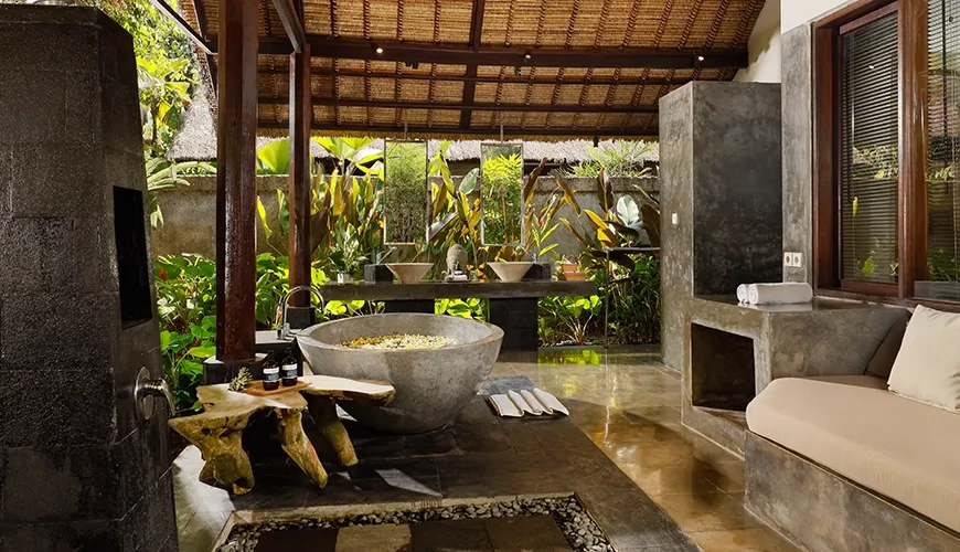 Luxurious outdoor bathroom features a stone tub and dual vanity sinks at Omecure