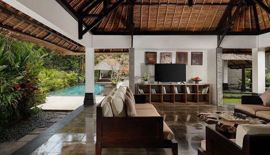 Open-plan living features traditional thatched roof and comfortable lounge area at Omecure