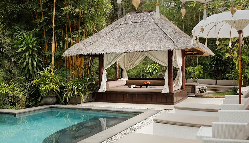 Tranquil pool area features a thatched gazebo and lush bamboo surroundings at Omecure