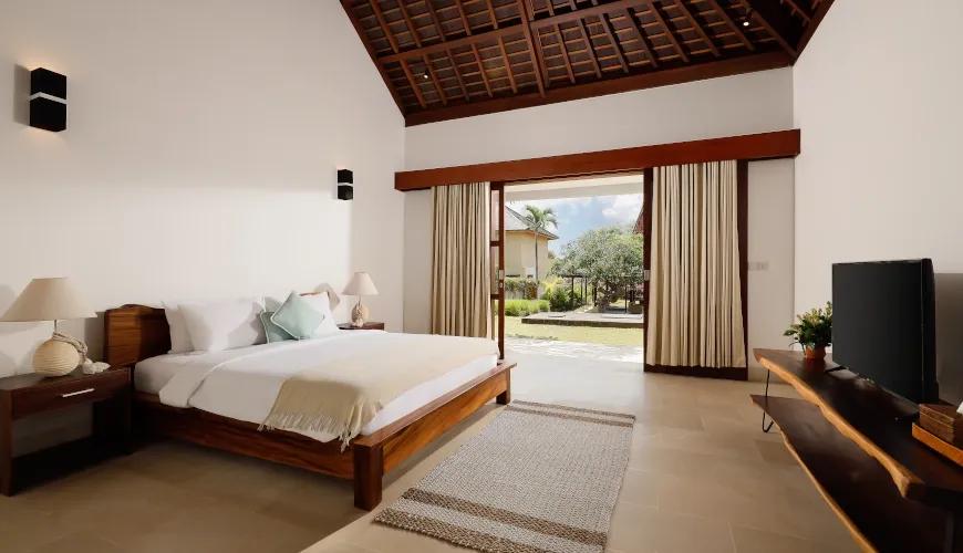 Comfortable Balinese bedroom with a vaulted wooden ceiling and an outdoor patio at Omegia Canggu