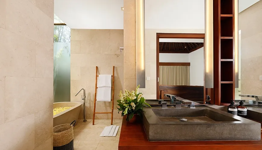 Elegant bathroom with a soaking tub and stone sink at Omegia Canggu