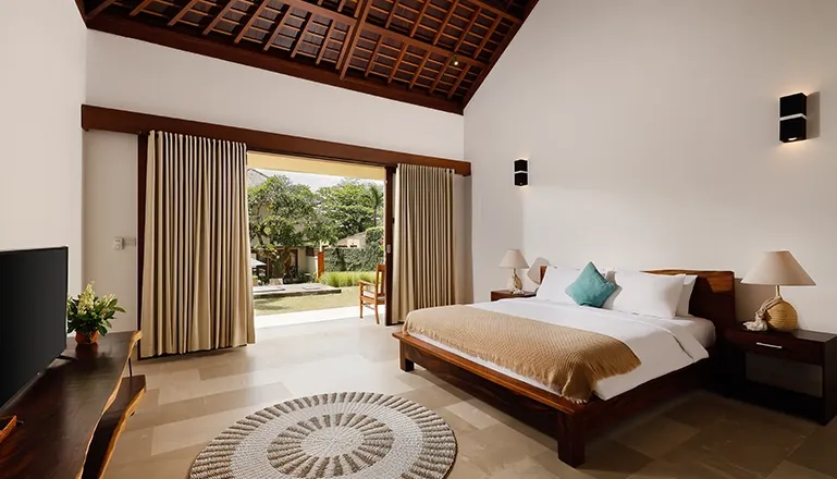 Spacious bedroom featuring a comfortable bed and light walls at Omegia Canggu