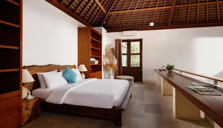 Tropical-style bedroom with a high vaulted wooden ceiling and custom wooden furniture at Omegia Canggu