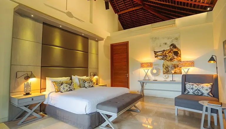 Relaxing sleeping space featuring warm wood and white walls at Omekai Cemagi