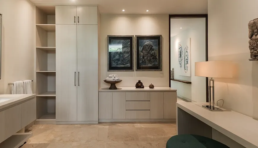 Spacious luxury villa bathroom with extensive built-in cabinetry, elegant marble floors, and decorative artwork above the counter at Omekai Cemagi