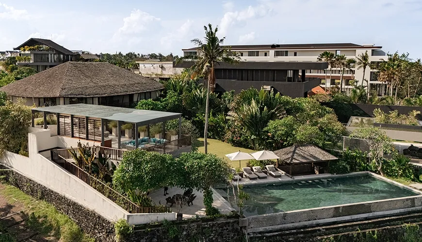 Wide drone view of the luxury villa resort featuring a private infinity pool surrounded by lush tropical gardens and unique architecture at Omekai Cemagi