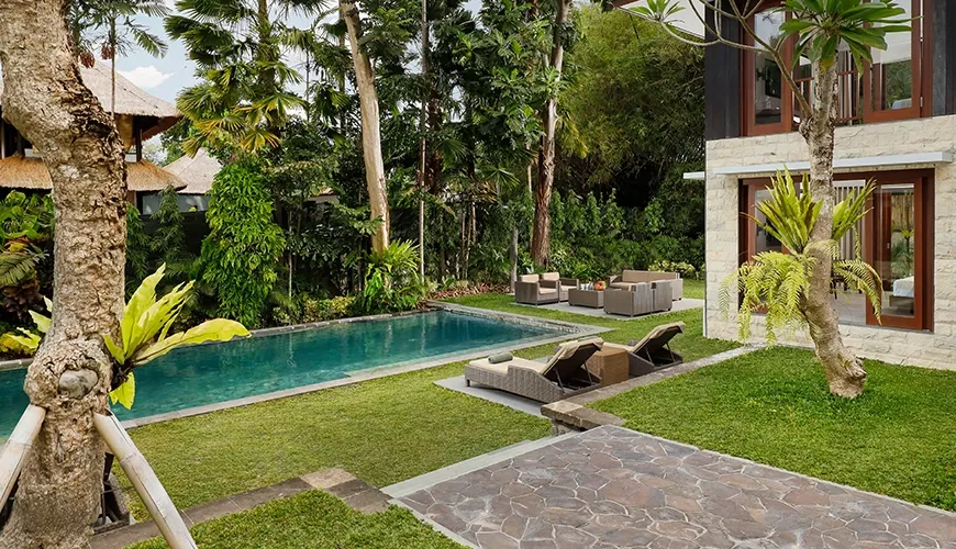 Lush tropical garden with swimming pool and outdoor lounge at Omekali