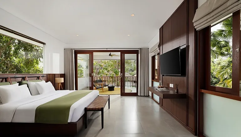 Spacious bedroom with king bed and balcony garden views at Omekali