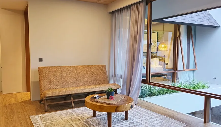 Cozy sitting area with woven bench and courtyard view at Pulang Villas