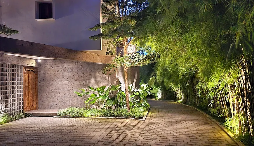 lluminated villa entrance with bamboo trees and modern architecture at Pulang Villas