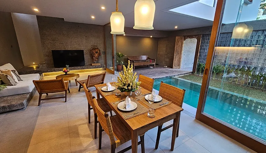 Modern dining area with pool view and stylish pendant lights at Pulang Villas
