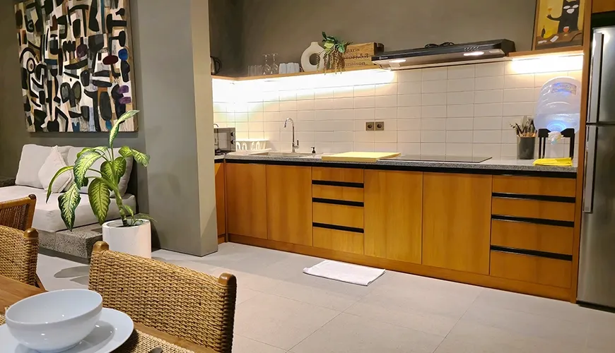 Modern kitchen with wooden cabinets and stainless steel appliances at Pulang Villas