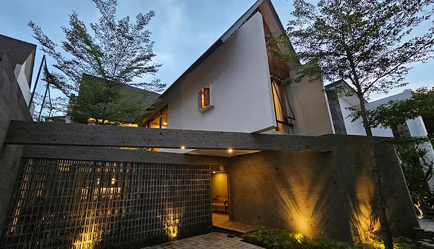 Modern villa exterior with striking angled roof and illuminated entrance at Pulang Villas