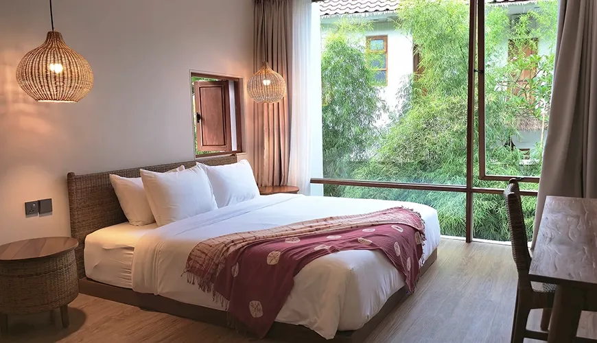 Spacious bedroom with king bed and lush green views at Pulang Villas