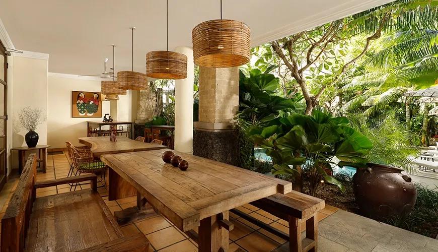 Rustic outdoor lounge area wooden tables benches rattan light fixtures at Sara Residence