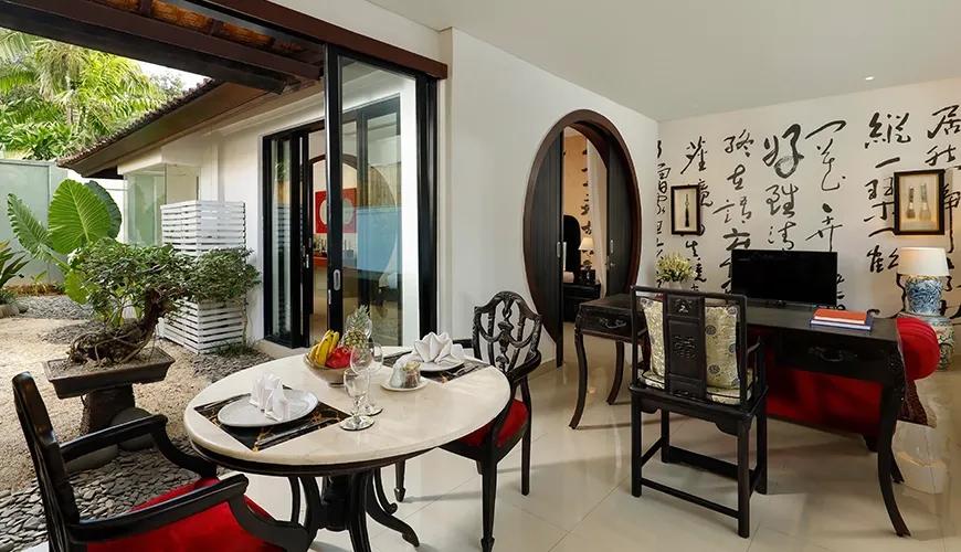 Elegant villa living room with marble dining table and traditional dark wood chairs at Shanti Estate 1BR