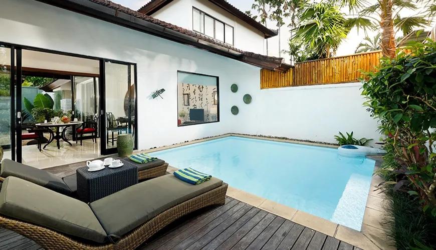 Tranquil villa swimming pool surrounded by a manicured patio and comfortable lounge chairs for relaxation at Shanti Estate 1BR