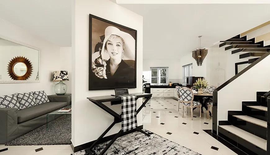 Contemporary dining and living space with checkered accents and a large portrait in a bright villa at Shanti Estate