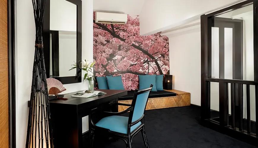 Modern Japanese themed workspace with a built in sofa bench and vibrant cherry blossom tree wallpaper at Shanti Estate