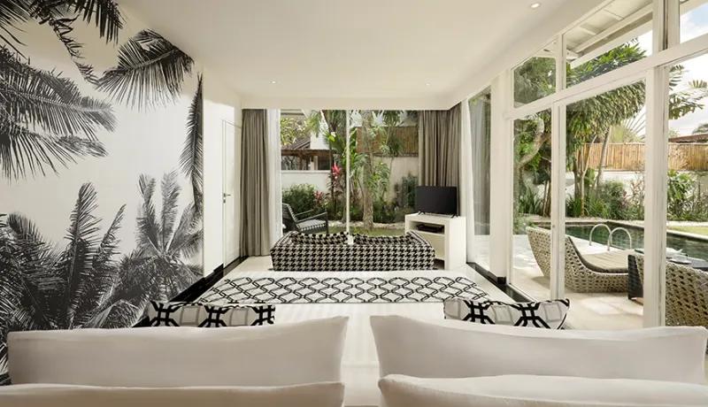 Modern monochrome bedroom with palm tree mural large glass windows and view of private swimming pool at Shanti Estate