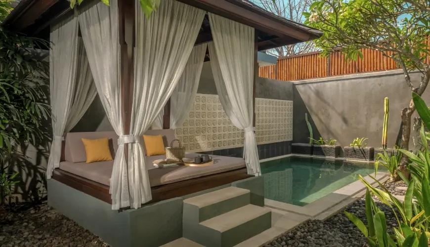 Private villa pool area featuring a wooden gazebo with white curtains and a relaxing tea set at Shanti Residence