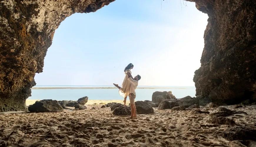 Romantic couple posing for a beautiful photo inside a beach cave with a scenic ocean view at Shanti Residence