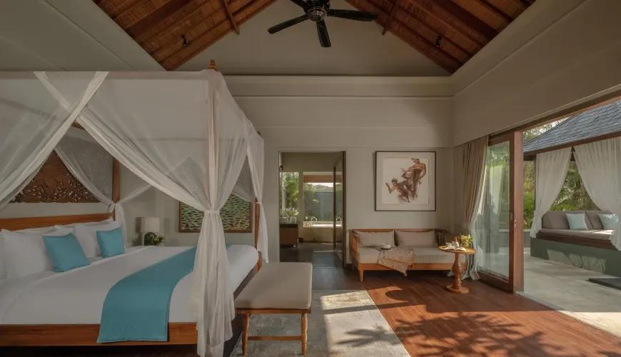 Spacious villa bedroom featuring a canopy bed, wooden ceilings, and sliding doors leading to a private gazebo at Shanti Residence