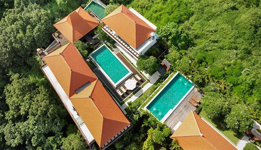 Aerial view of a sprawling villa complex with multiple pools nestled in lush greenery at The Bija Villas