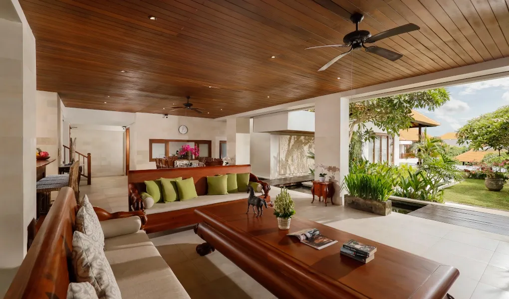 Open-air living room with traditional wood furniture and garden views at The Bija Villas