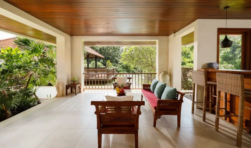Shaded outdoor lounge space with a bar and traditional furniture at The Bija Villas