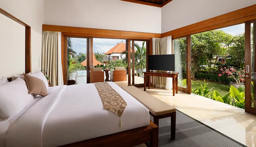 Spacious master bedroom with a large bed, traditional wooden ceiling, and sliding doors to a patio at The Bija Villas