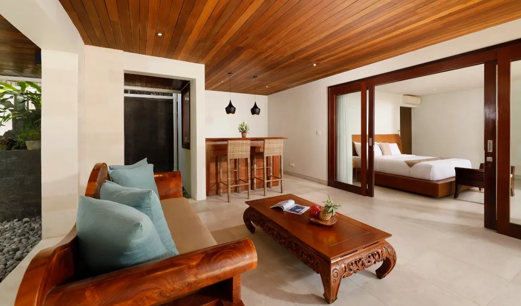 Stylish lounge area with a small bar and adjoining bedroom at The Bija Villas