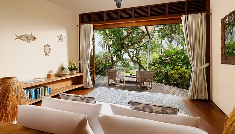 Bright bedroom features a large bed and private outdoor lounge area at The Cove Bali