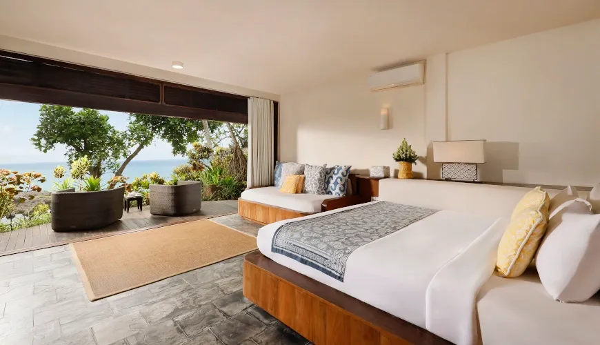 Elegant bedroom with ocean view from large sliding glass doors at The Cove Bali
