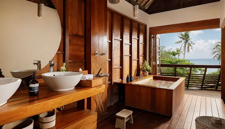 Luxurious bathroom features a wooden tub and stunning panoramic ocean views at The Cove Bali
