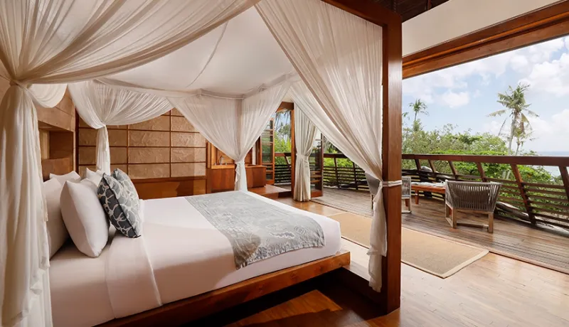 Master bedroom features a draped four-poster bed and private ocean-view balcony at The Cove Bali