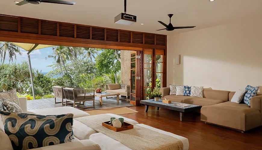 Open living room features comfortable sofas and direct outdoor ocean access at The Cove Bali