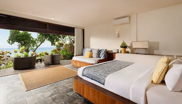 Spacious bedroom features a daybed and direct access to oceanfront patio at The Cove Bali