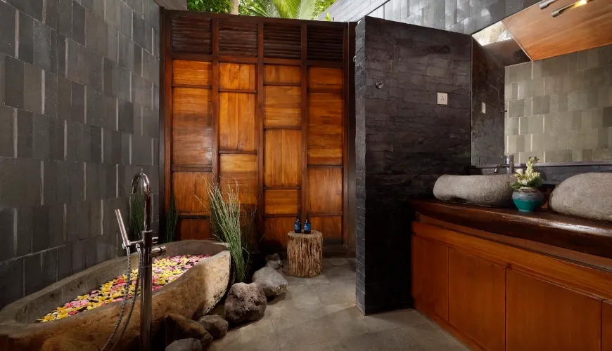 Unique Bali bathroom with stone tub and wooden paneling at The Cove Bali